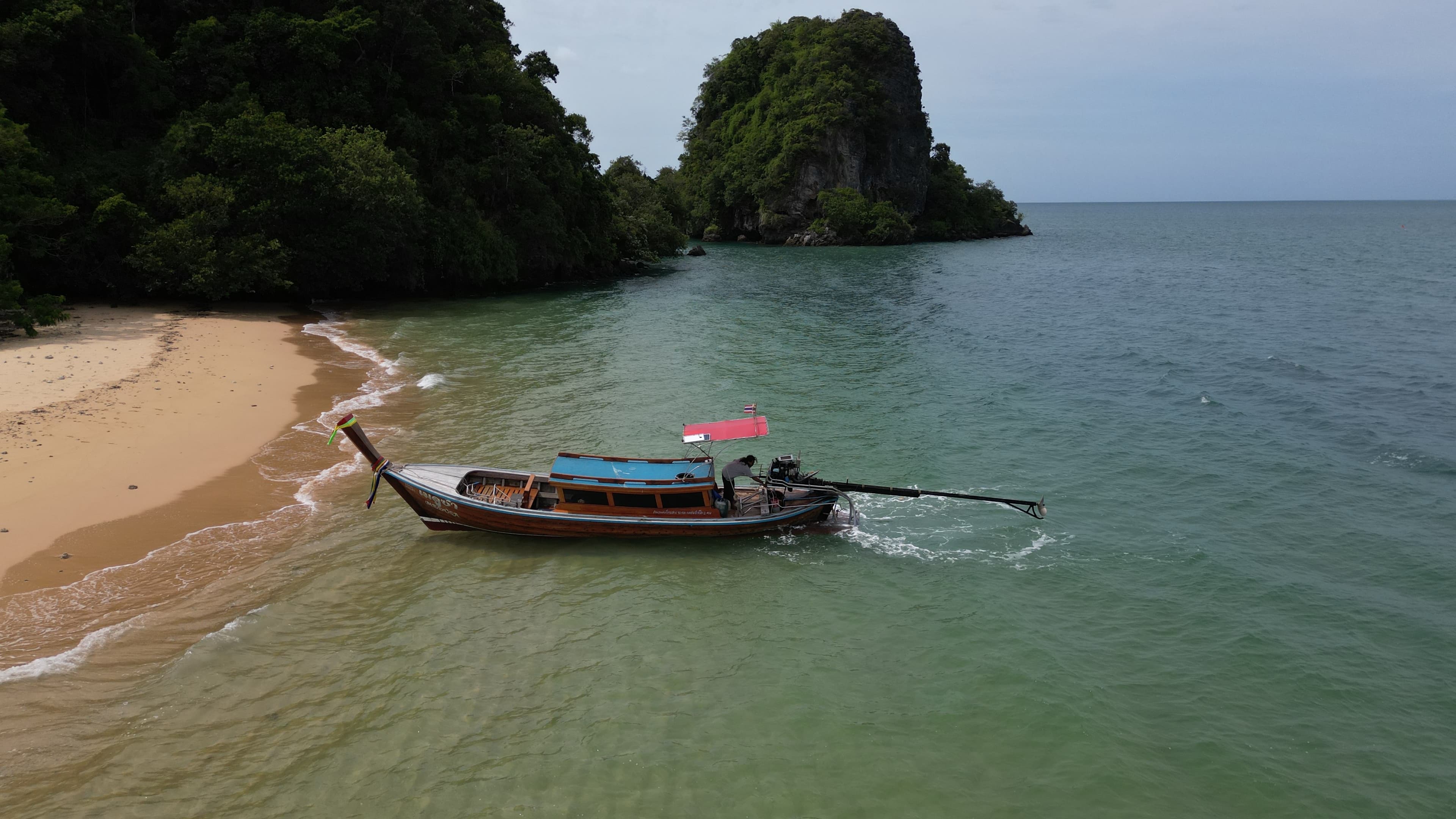 Private longtail boat beside a quiet tropical island in Phuket